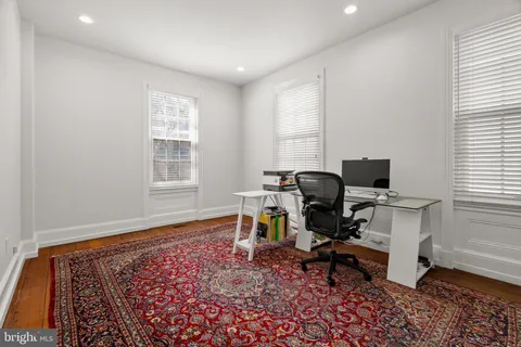 a view of hallway with wooden floor and a rug