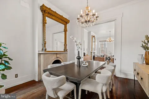 a living room with furniture a fireplace and a chandelier