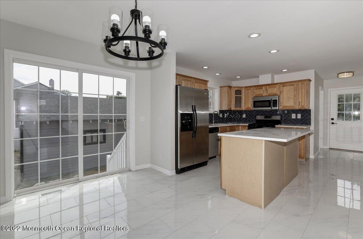 110 Island Road Toms River, NJ 08753 - Photo 18 of 51 a kitchen with stainless steel appliances kitchen island granite countertop a refrigerator and a sink