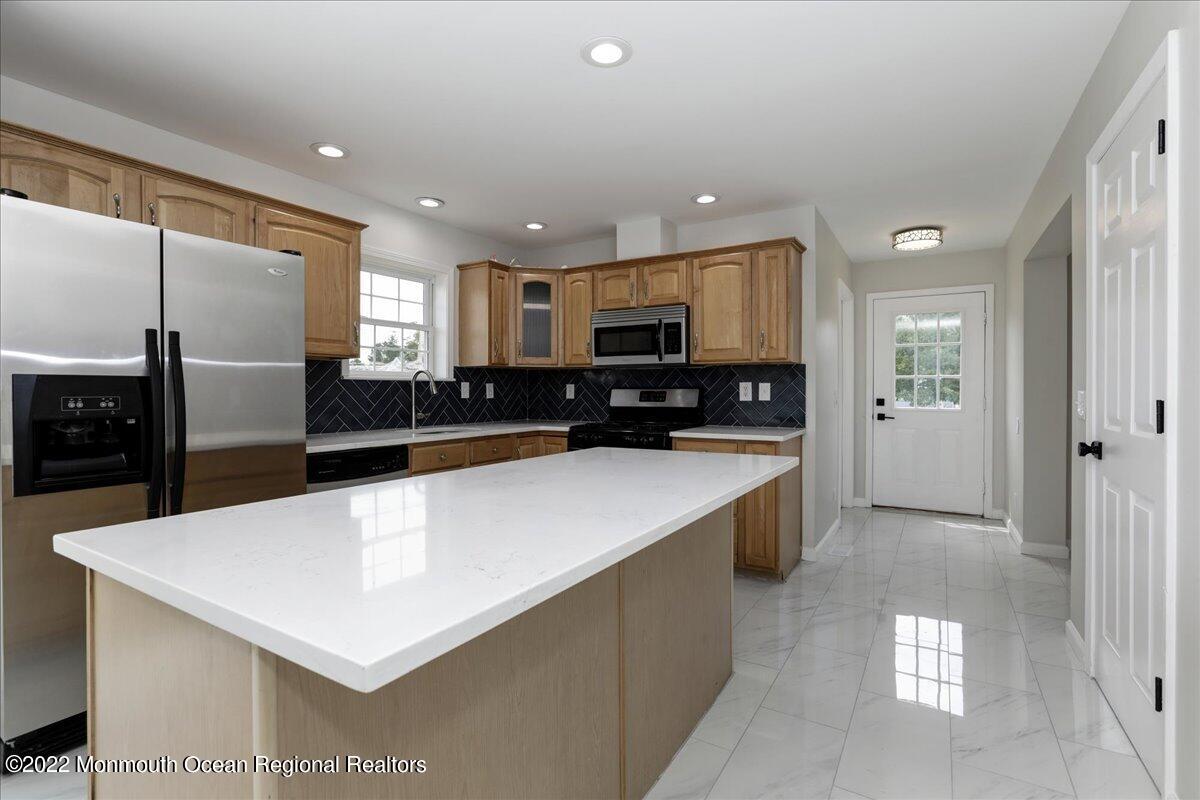 110 Island Road Toms River, NJ 08753 - Photo 19 of 51 a large kitchen with stainless steel appliances a large counter top a refrigerator and a sink