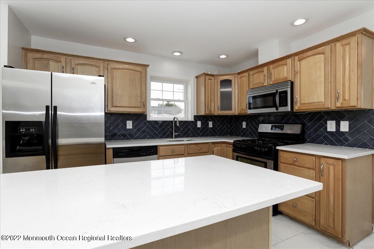 110 Island Road Toms River, NJ 08753 - Photo 21 of 51 a large kitchen with stainless steel appliances a large counter top a stove a microwave a sink a refrigerator and cabinets