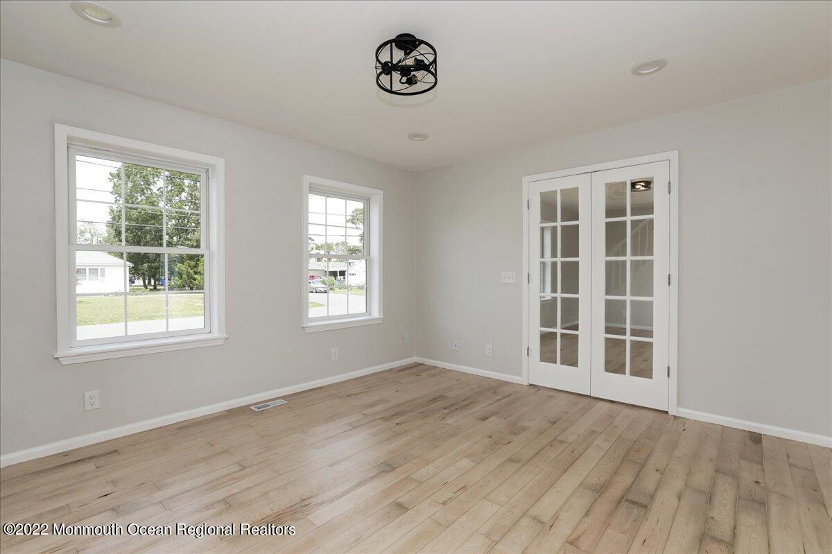 110 Island Road Toms River, NJ 08753 - Photo 8 of 51 an empty room with wooden floor and windows