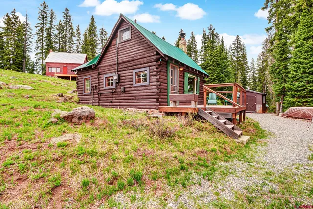 an aerial view of a house with swimming pool and red chairs