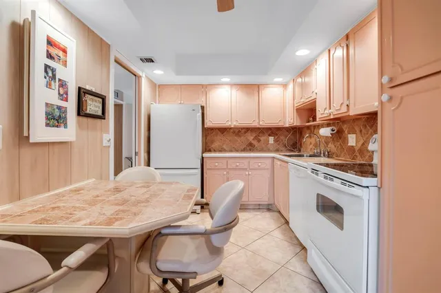 a kitchen with white cabinets and white appliances
