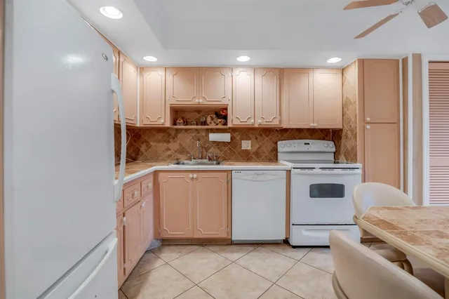 a kitchen with granite countertop a sink stainless steel appliances and cabinets