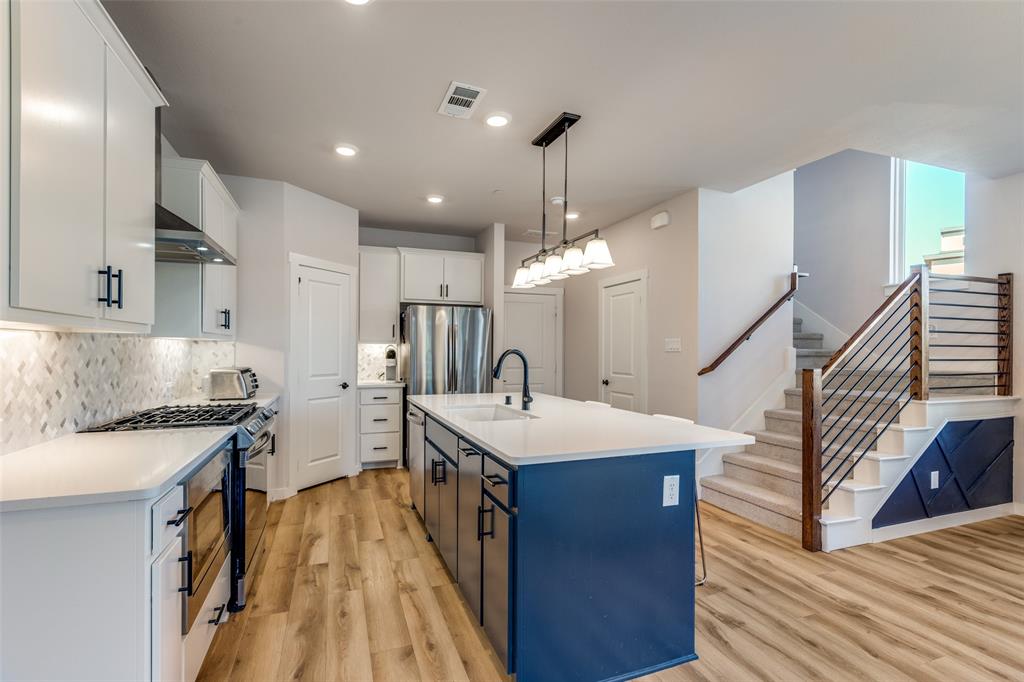 720 Bandera Court Prosper, TX 75078 - Photo 7 of 24 a open kitchen with stainless steel appliances granite countertop a sink a stove and a refrigerator