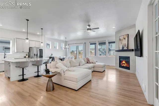 a living room with furniture a fireplace and a chandelier