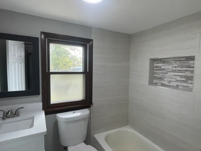 a bathroom with a toilet sink and mirror