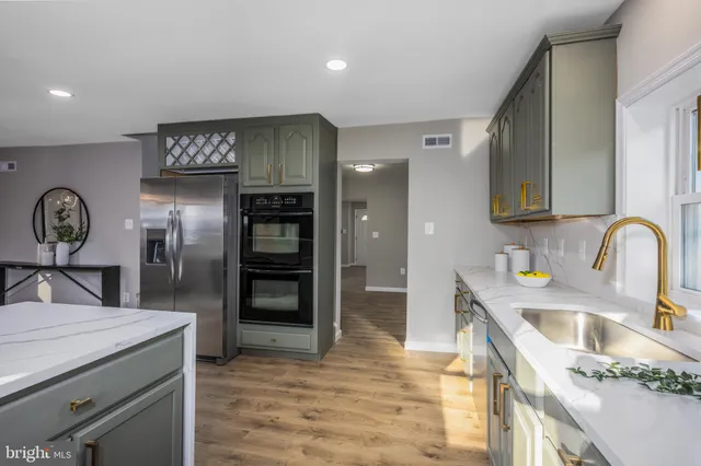 a kitchen with stainless steel appliances granite countertop a sink and refrigerator