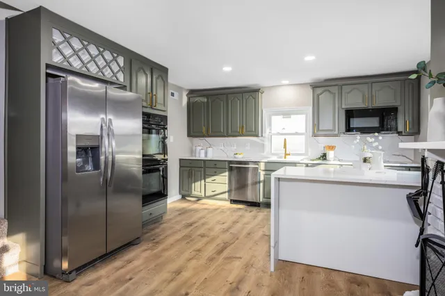 a kitchen with granite countertop a refrigerator stove top oven and sink