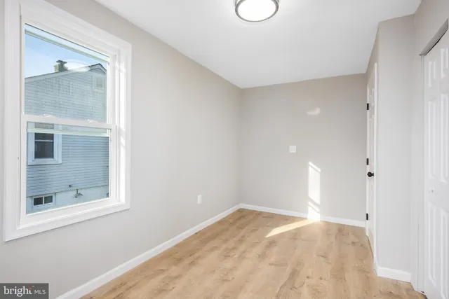 a view of empty room with window and bathroom
