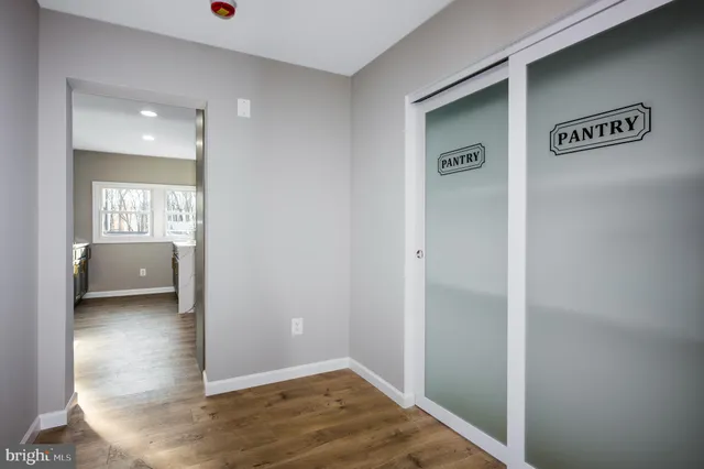 a view of a livingroom and a hallway to a livingroom with wooden floor