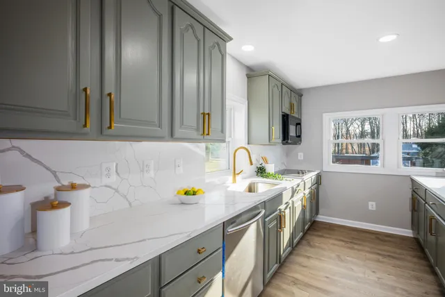 a kitchen with stainless steel appliances a sink a stove and cabinets