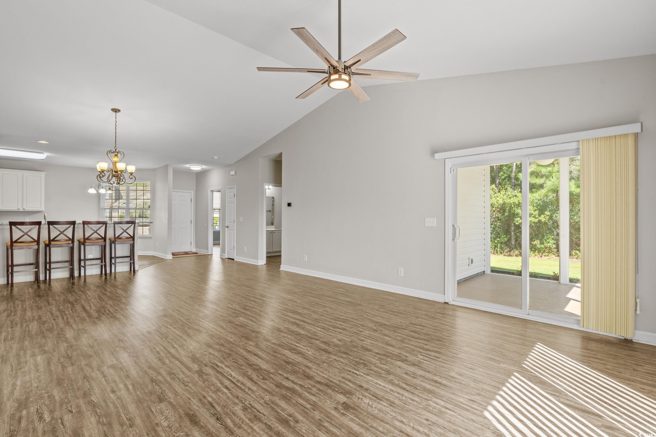 562 Tuckahoe Road Myrtle Beach, SC 29579 - Photo 12 of 40 Unfurnished living room with light wood-style floors, a chandelier, plenty of natural light, ceiling fan, and high vaulted ceiling