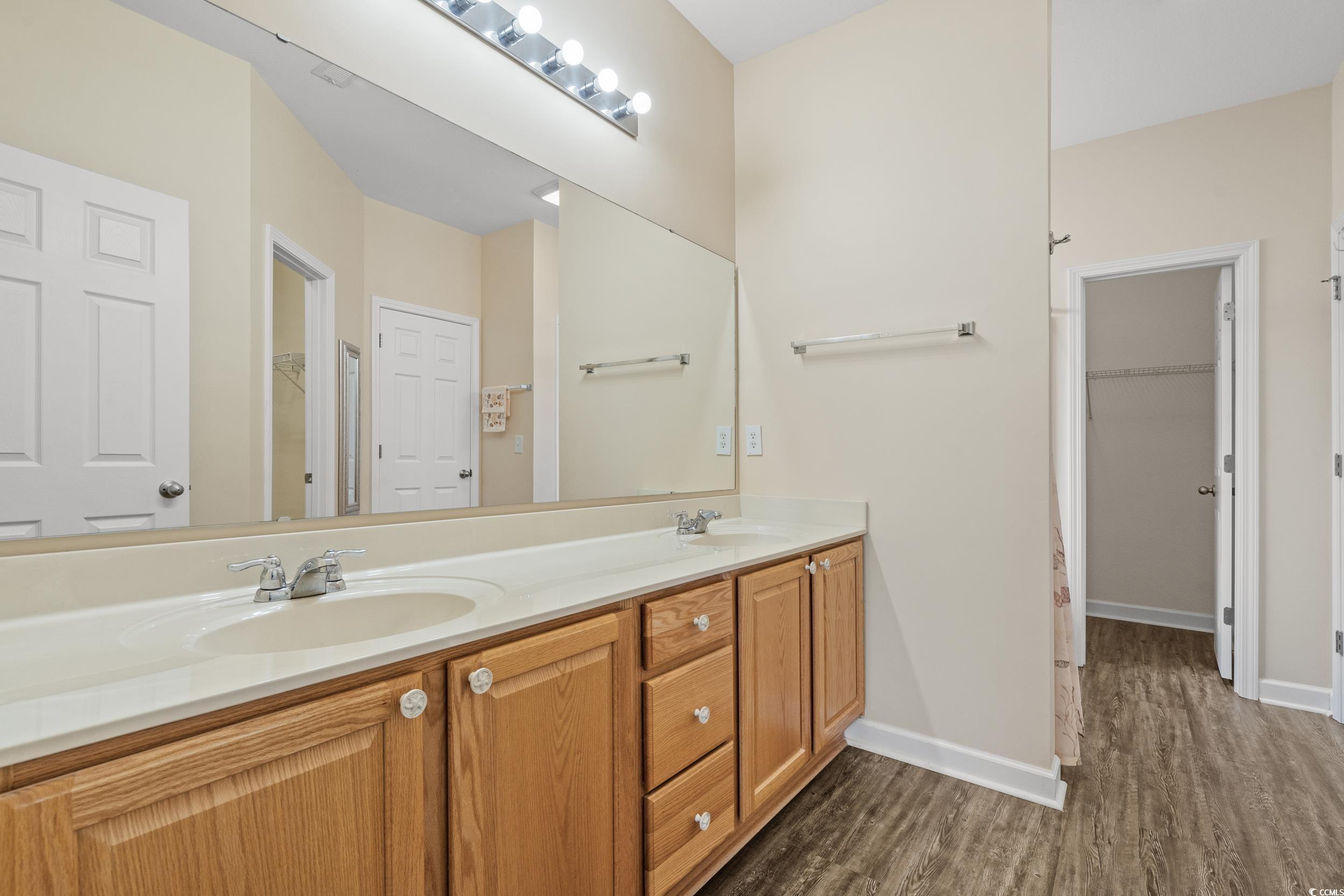 562 Tuckahoe Road Myrtle Beach, SC 29579 - Photo 21 of 40 Bathroom with a walk in closet, double vanity, and dark wood-style floors