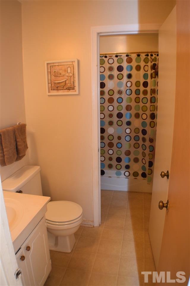 7613 Mine Valley Road Raleigh, NC 27615 - Photo 11 of 24 a bathroom with a toilet and a shower curtain