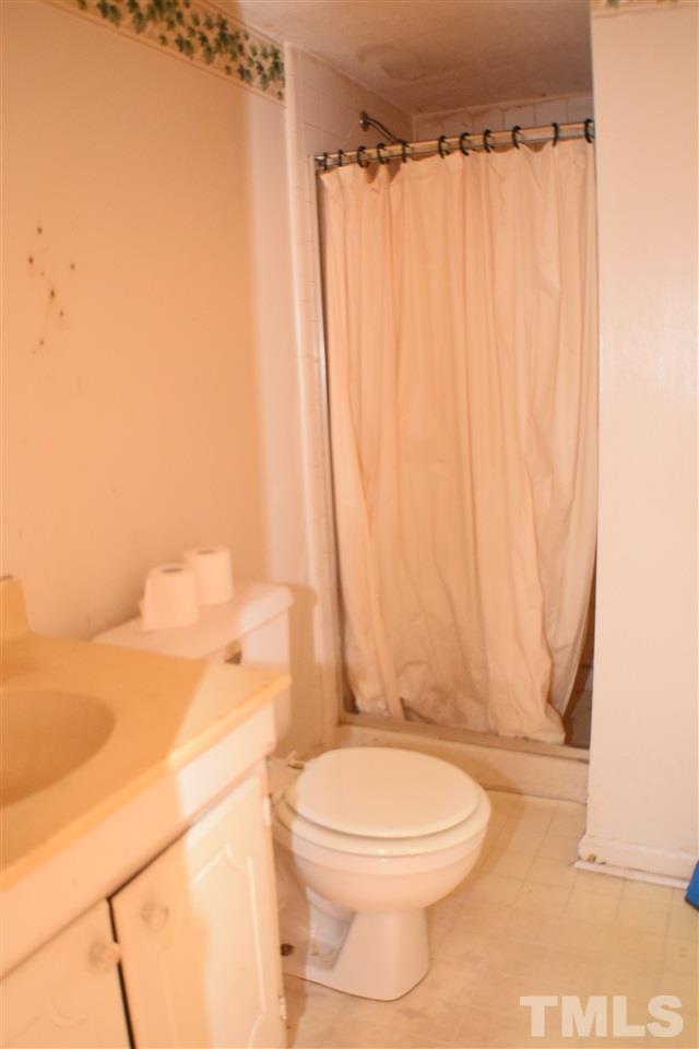 7613 Mine Valley Road Raleigh, NC 27615 - Photo 21 of 24 a bathroom with a toilet and a shower curtain