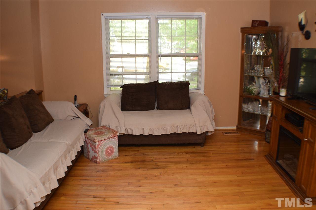 7613 Mine Valley Road Raleigh, NC 27615 - Photo 5 of 24 a living room with furniture a flat screen tv and a fireplace