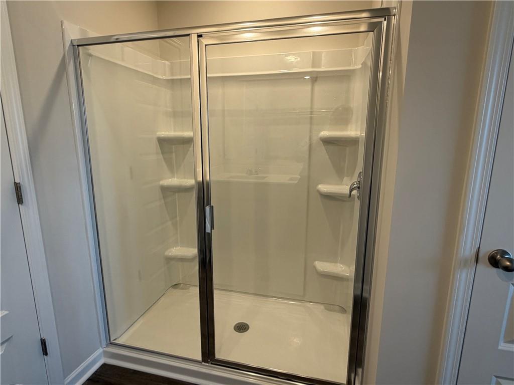 79 Holland Cove Winder, GA 30680 - Photo 13 of 25 a bathroom with a glass shower door