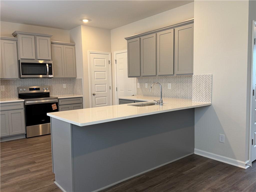 79 Holland Cove Winder, GA 30680 - Photo 6 of 25 a kitchen with kitchen island granite countertop a sink stove and refrigerator