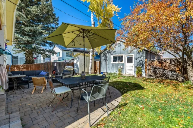 a view of house with backyard and outdoor seating