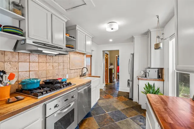a kitchen with stove and cabinets
