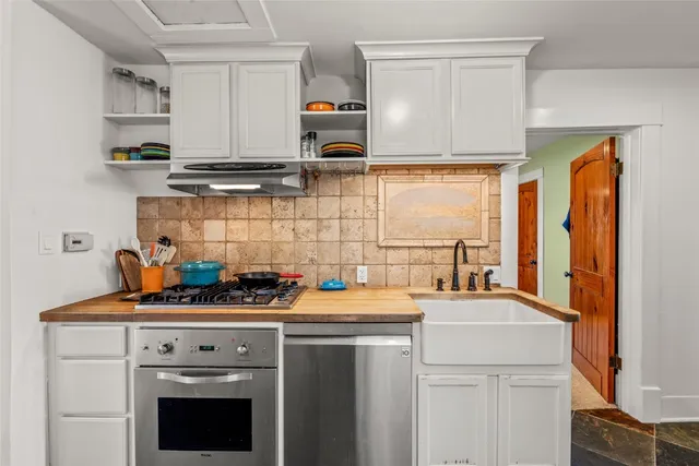a kitchen with stainless steel appliances a sink stove and cabinets