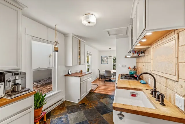 a living room with furniture a flat screen tv and a sink