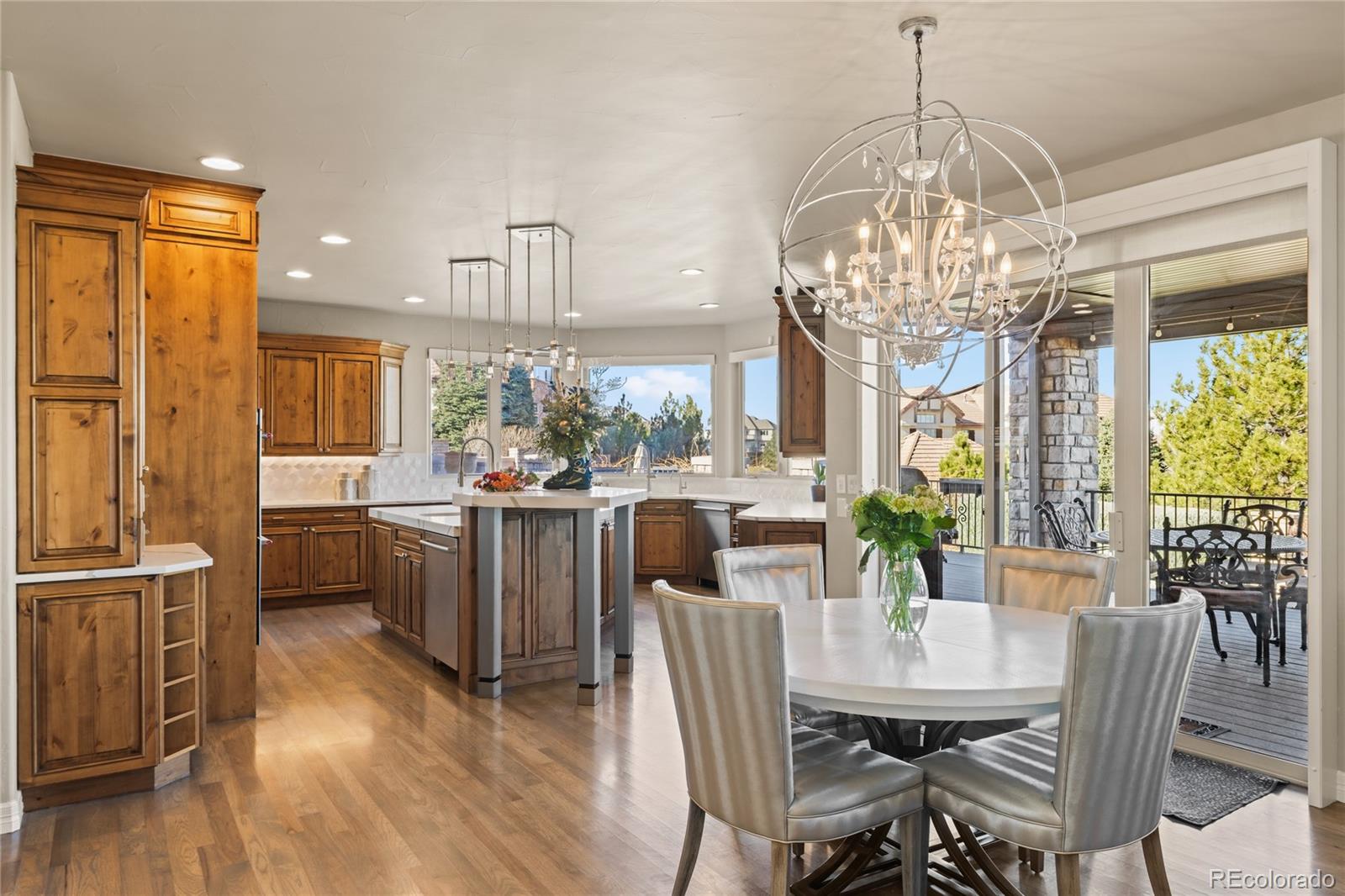 8751 Crooked Stick Place Lone Tree, CO 80124 - Photo 16 of 50 a dining room filled chandelier and wooden floor