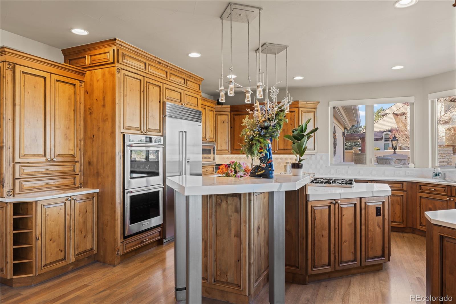 8751 Crooked Stick Place Lone Tree, CO 80124 - Photo 17 of 50 a kitchen that has a lot of cabinets and wooden floor