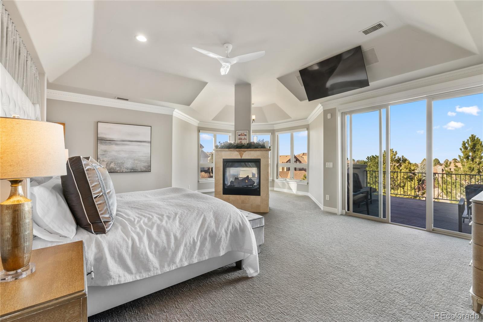 8751 Crooked Stick Place Lone Tree, CO 80124 - Photo 32 of 50 a spacious bedroom with a bed and a fireplace
