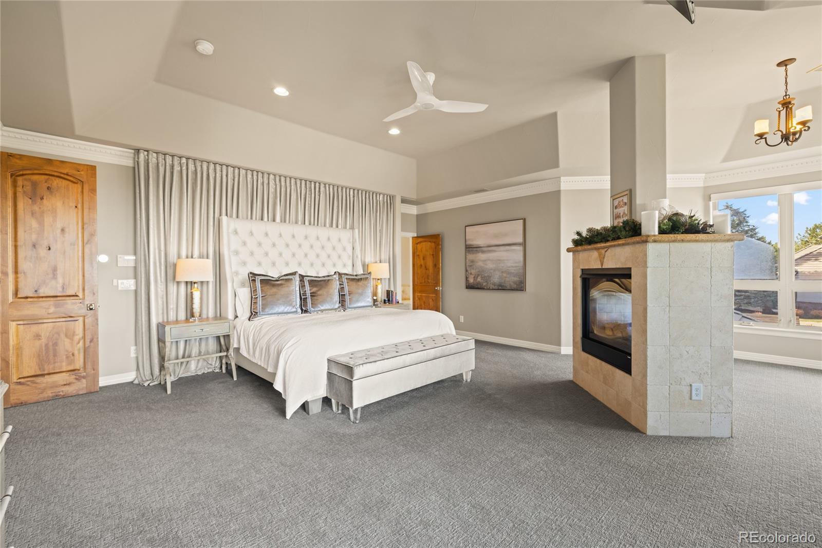 8751 Crooked Stick Place Lone Tree, CO 80124 - Photo 33 of 50 a spacious bedroom with a bed and a fireplace