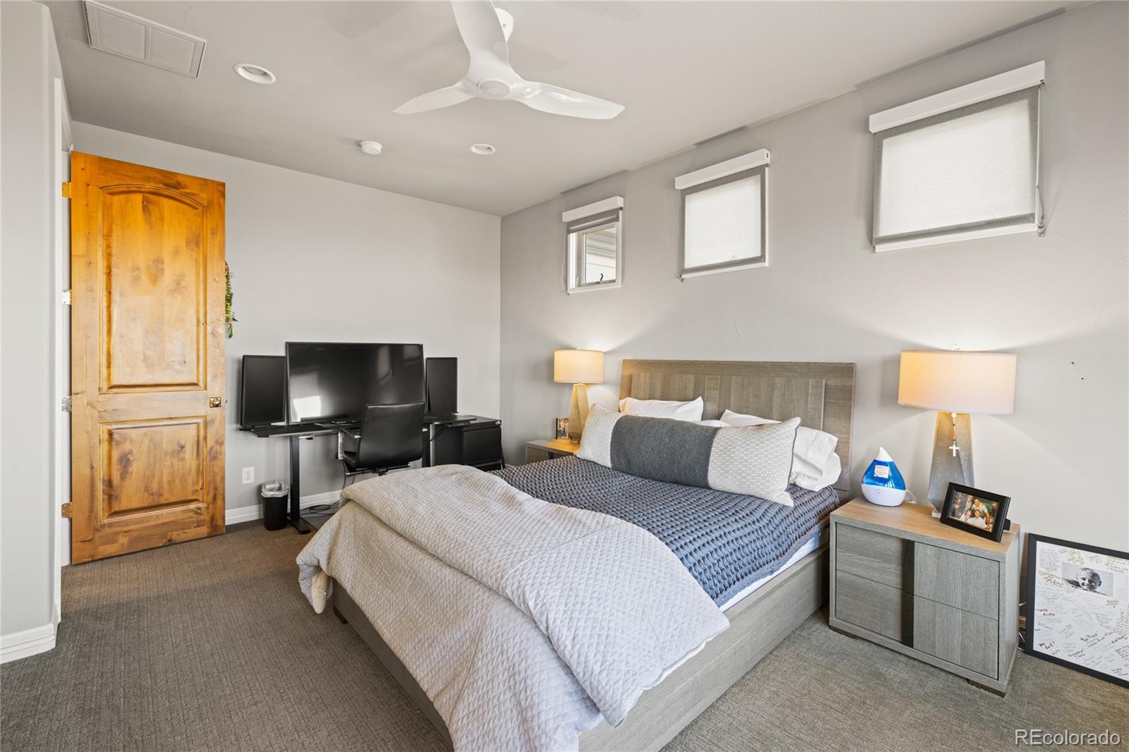 8751 Crooked Stick Place Lone Tree, CO 80124 - Photo 43 of 50 a bedroom with a bed and a flat tv screen on the dresser