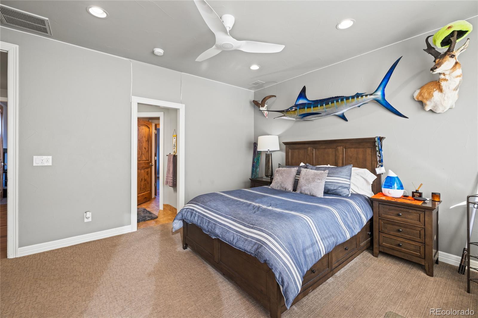 8751 Crooked Stick Place Lone Tree, CO 80124 - Photo 46 of 50 a bedroom with a bed and a chandelier