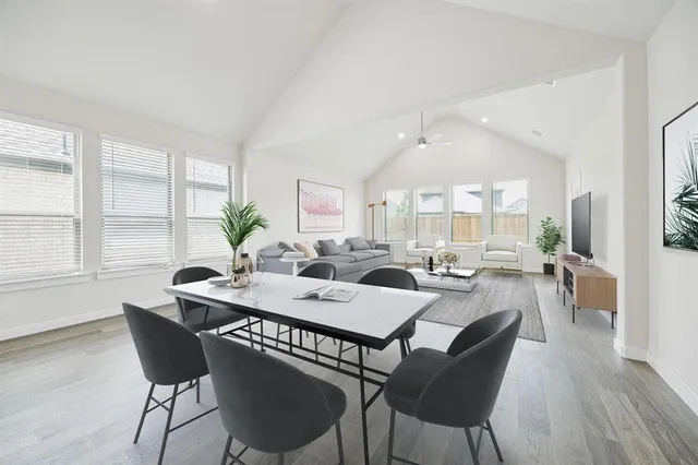a view of a dining room and livingroom with lots of furniture wooden floor and a rug