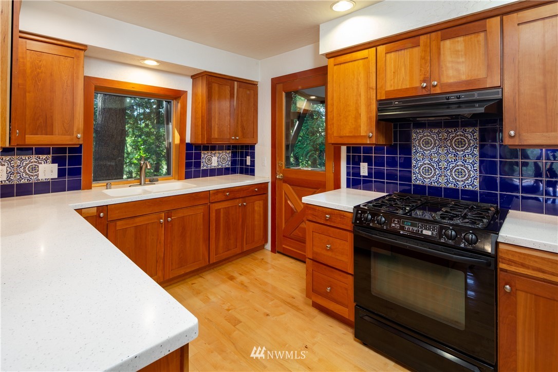 5852 Storr Road Ferndale, WA 98248 - Photo 8 of 25 a kitchen with granite countertop a stove top oven cabinetry a sink and a refrigerator