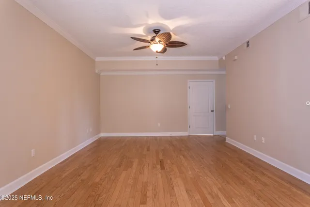 a view of a room with wooden floor closet and a chandelier fan
