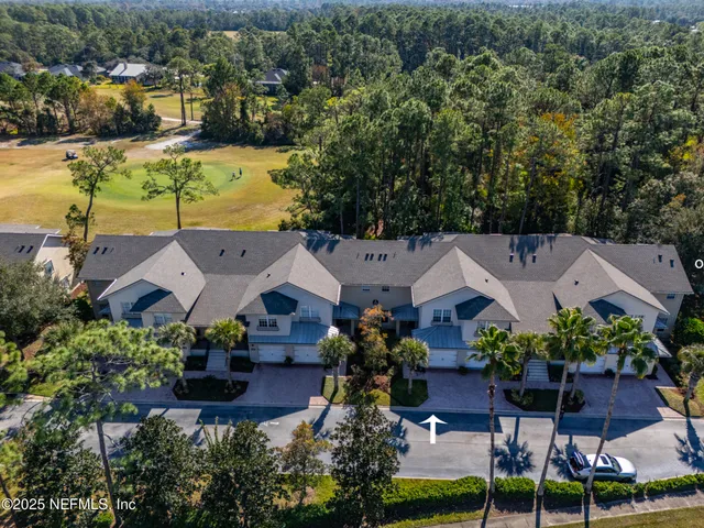 an aerial view of multiple houses with yard
