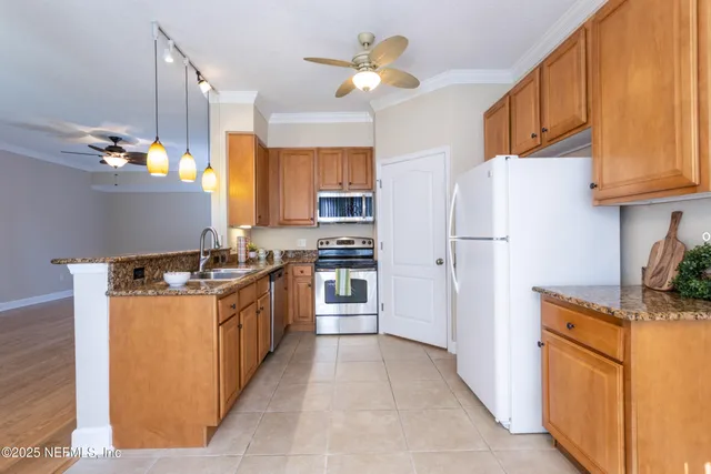 a kitchen with stainless steel appliances granite countertop a refrigerator a stove and a sink