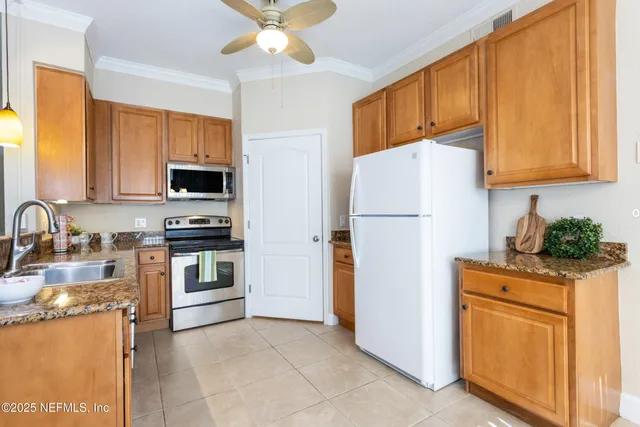 a kitchen with granite countertop a refrigerator stove and sink