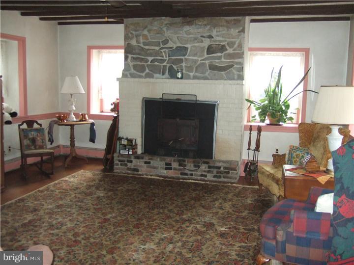 4052 Lehnenberg Road Riegelsville, PA 18077 - Photo 8 of 19 a living room with furniture a fireplace and a large window