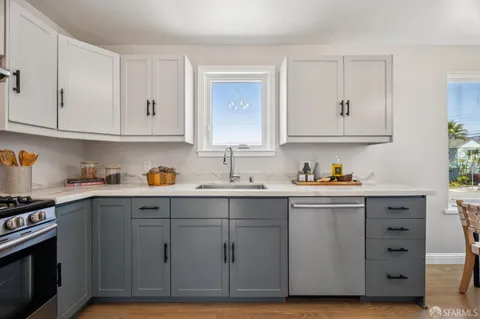 a kitchen with stainless steel appliances a refrigerator a stove a dining table and chairs