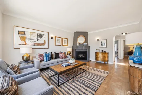 a living room with furniture a rug and a lamp