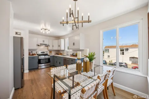 a kitchen with granite countertop white cabinets and stainless steel appliances