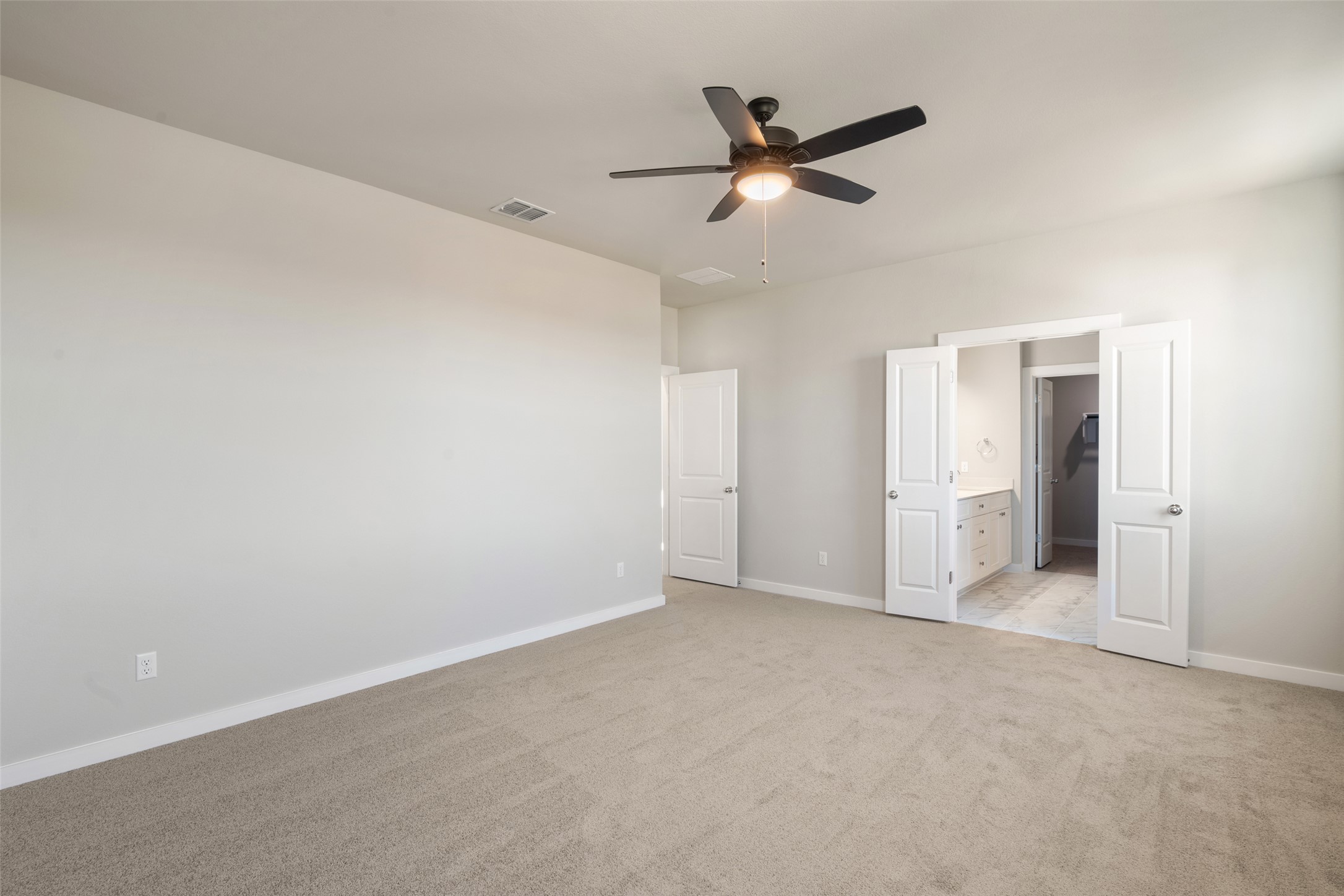 17408 Monastrell Lane Pflugerville, TX 78664 - Photo 20 of 31 Unfurnished bedroom with light carpet, a ceiling fan, and ensuite bath
