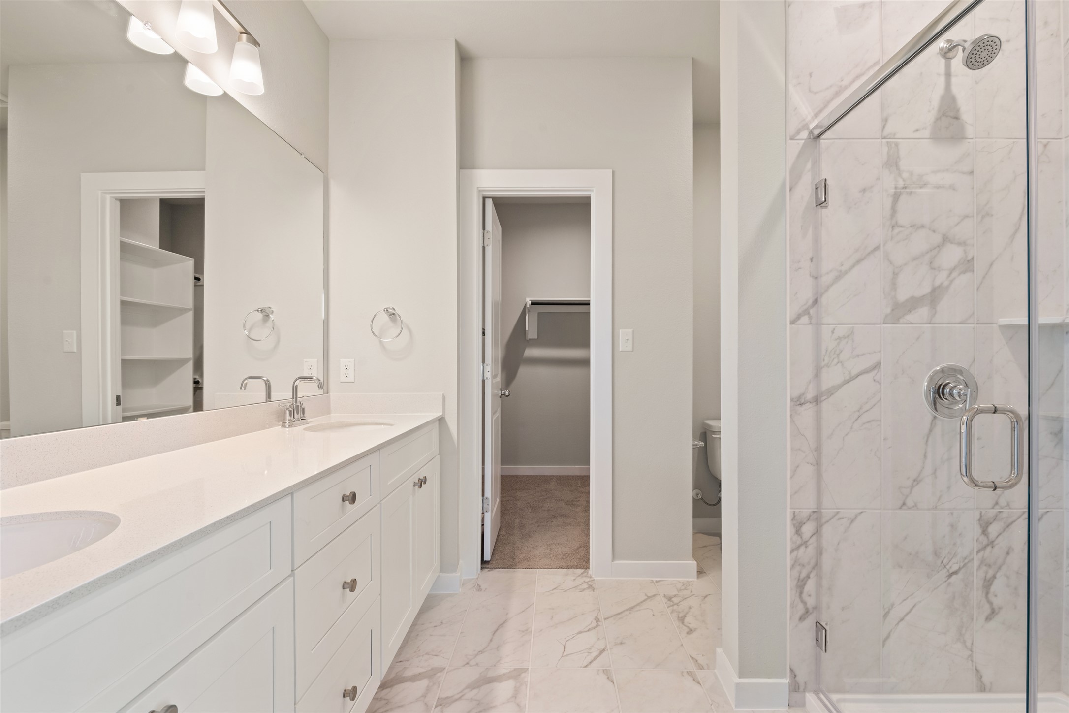 17408 Monastrell Lane Pflugerville, TX 78664 - Photo 21 of 31 Full bathroom with light marble finish floors, a marble finish shower, a spacious closet, and double vanity