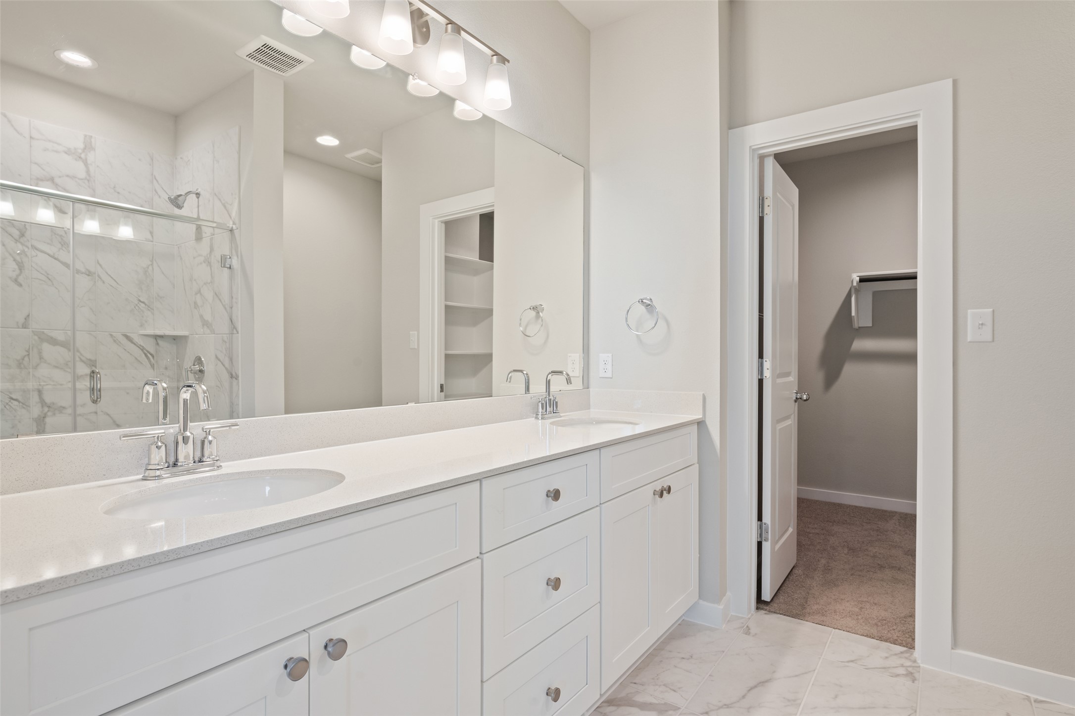 17408 Monastrell Lane Pflugerville, TX 78664 - Photo 22 of 31 Bathroom featuring a walk in closet, light marble finish flooring, a marble finish shower, double vanity, and recessed lighting