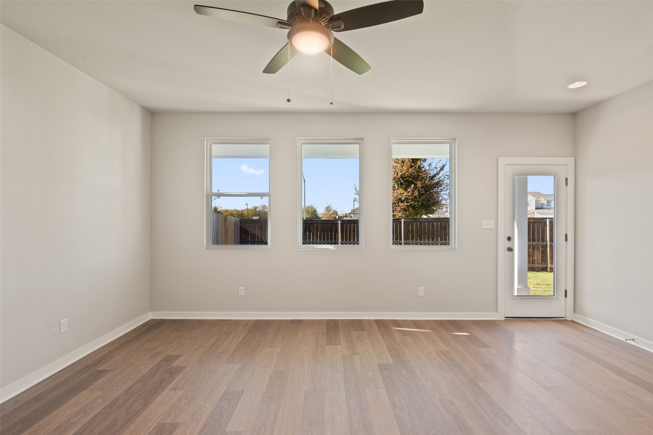 17408 Monastrell Lane Pflugerville, TX 78664 - Photo 8 of 31 Empty room with light wood-style floors and ceiling fan