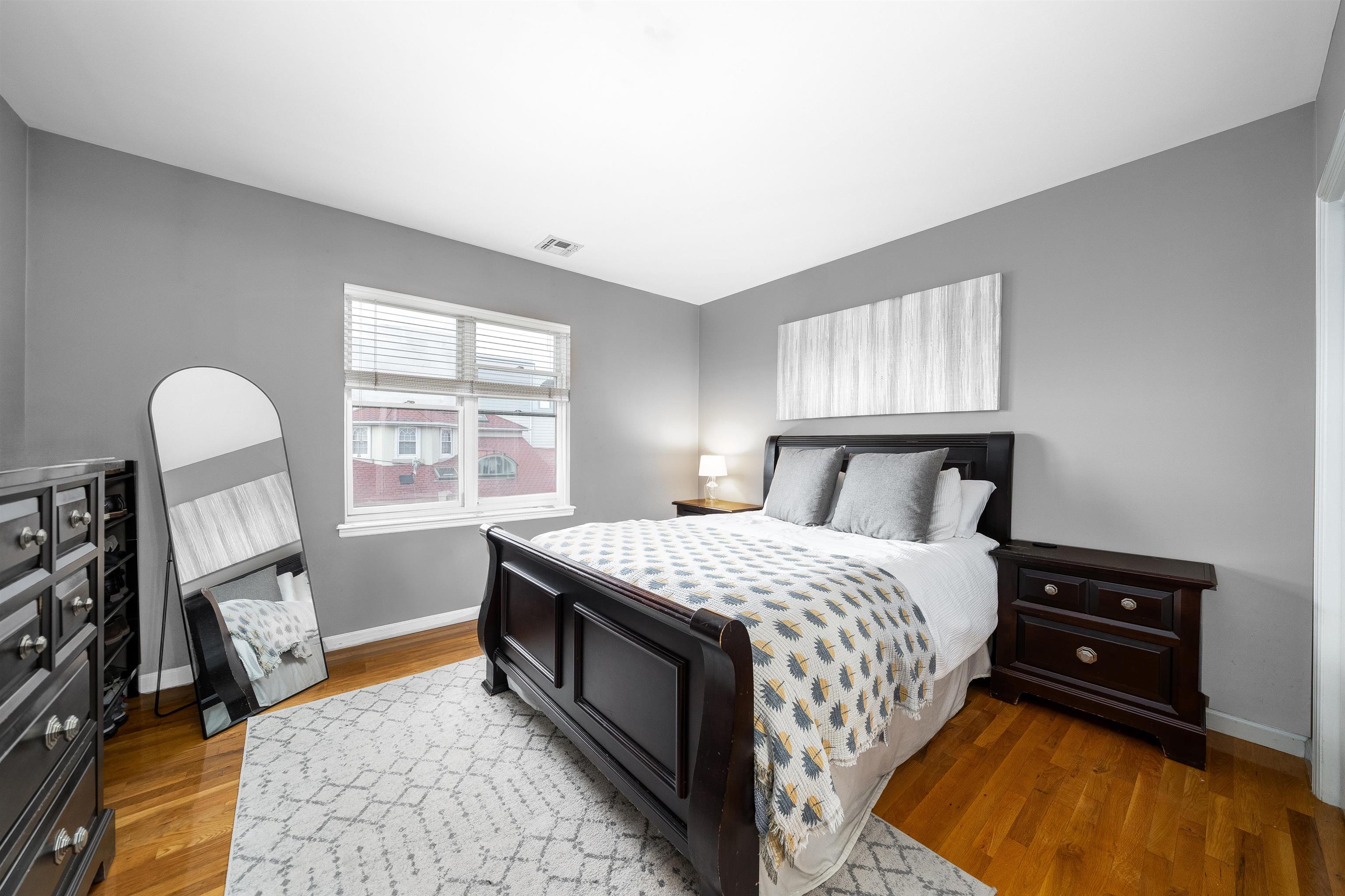 536 Grand Street, Unit 403 Hoboken, NJ 07030 - Photo 6 of 15 a bedroom with a bed and a dresser next to a window