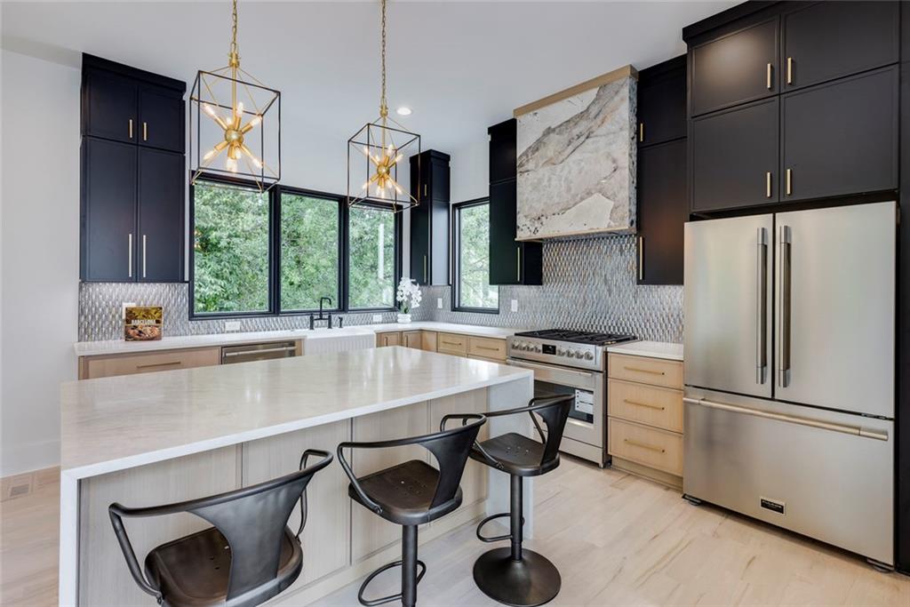 551 Sunset Drive Norcross, GA 30071 - Photo 14 of 45 a kitchen with stainless steel appliances a sink a stove a refrigerator and cabinets